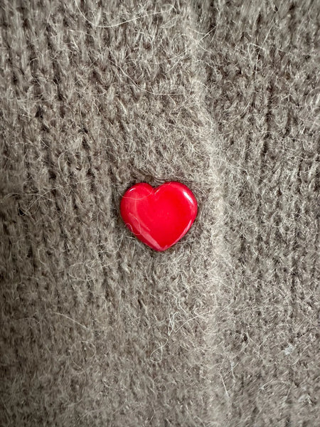 Gilet marron à manches longues avec des boutons en formes de cœurs roses, rouges et marrons, détail d'un bouton