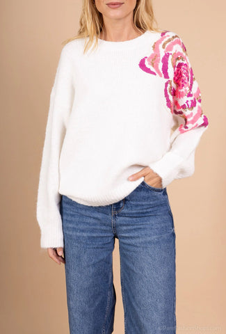 Pull blanc avec des sequins roses sur l'épaule gauche